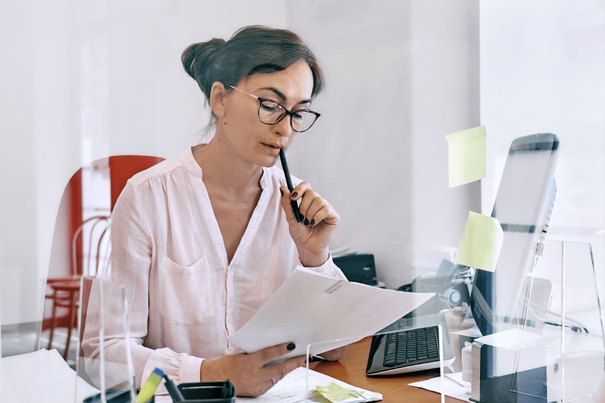 business woman looking at financial documents and thinking